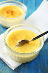 Creme brulee dessert  on napkin, on color wooden background