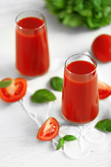 Tomato juice and fresh tomatoes on wooden table close-up