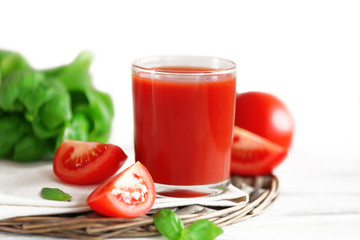 Tomato juice and fresh tomatoes on wooden table close-up