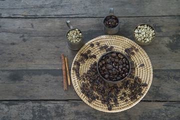 coffee beans raw and roasted in brass cup with wicker container