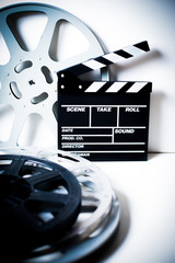 Movie clapper with film reels on white