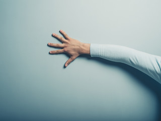 Male hand touching a blue wall