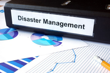 Graphs and file folder with label  Disaster Management. Business concept.
