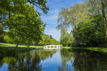 Fototapeta na wymiar A lake and small bridge in a Surrey park.
