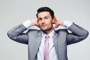 Portrait of a businessman covering his ears