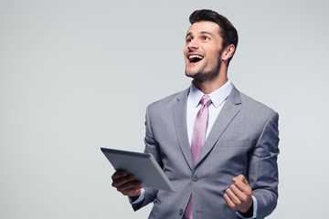 Cheerful businessman holding tablet computer