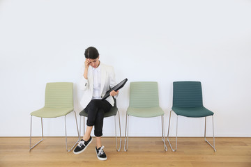 Woman sitting on chair waiting for job interview