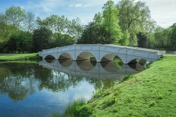 Fototapeten White bridge in a lake in a Surrey park. © oliverhuitson