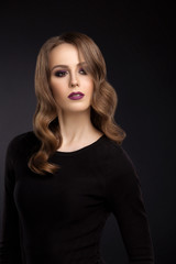Fototapeta premium Portrait of young girl with makeup and retouch on dark backgroun