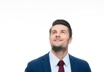 Happy thoughtful businessman looking up