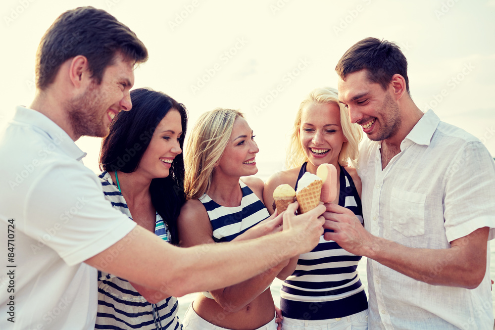 Wall mural smiling friends eating ice cream on beach