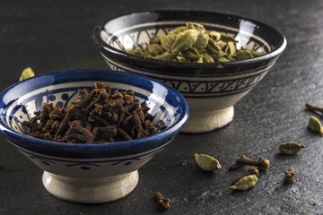 Cardamom and cloves in ceramic bowls