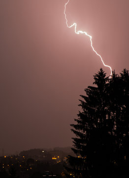 Isolates lightning with a tree and a city