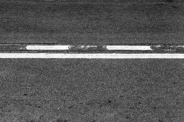 Asphalt road with dividing line and tire tracks