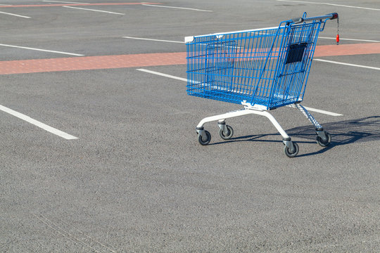 Empty shopping cart stands on a parking
