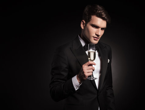Attractive young man holding a glass on wine