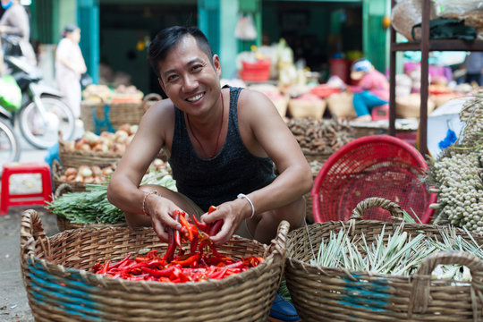 Asian man on street market smile sell red chilly pepper