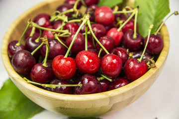 cherries many, wooden bowl, leaf