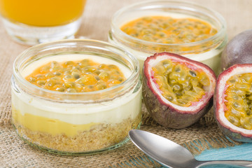 Mango & Passion Fruit Cheesecake - Individual potted dessert made with mango and passion fruit whipped cream and a biscuit base, topped with passion fruit pulp.

