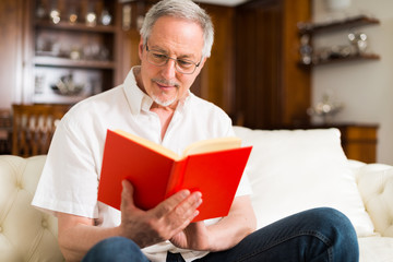 Happy mature man reading a book