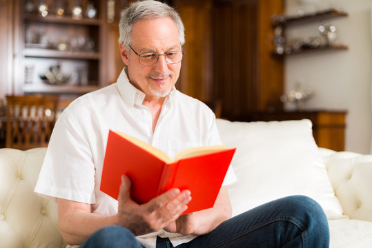 Happy mature man reading a book