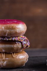 Stack of hand decorated artisan donut, wooden background