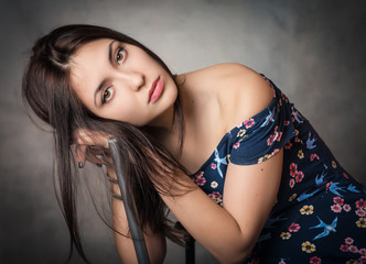 Fototapeta premium Sad beautiful woman in sundress on grey background.