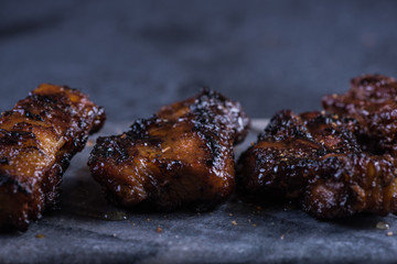 Grilled pork belly slices on marble board and slate background