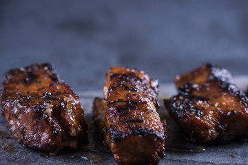 Grilled pork belly slices on marble board and slate background