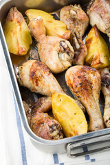 Roasted chicken drumsticks with potatoes.