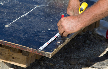 Worker with measuring tape and pencil