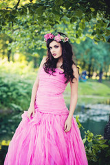 Fototapeta premium Fashion Girl Outdoors Portrait in Greenery Blooming Trees. Beaut