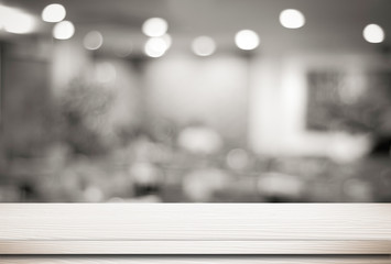 Empty white table and blurred cafe with bokeh light background