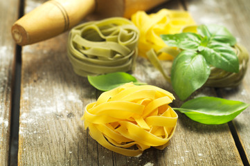  Italian pasta with fresh basil on the wooden surface. Selective focus