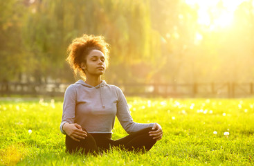 African american woman meditating in nature - obrazy, fototapety, plakaty