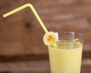 Milk shake made from banana on wooden background