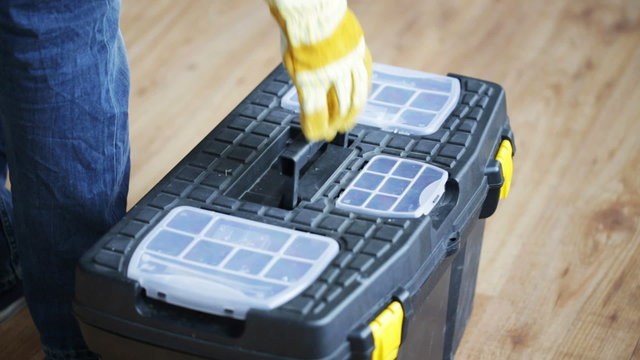 close up of man carrying tool box and leaving
