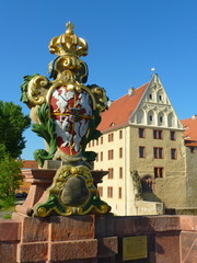 Wappenstein auf der Pöppelmannbrücke in Grimma in Sachsen mit Schloss