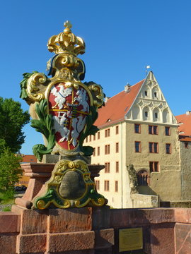 Wappenstein auf der P&ouml;ppelmannbr&uuml;cke in Grimma in Sachsen mit Schloss