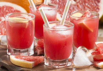 Pink grapefruit drink with pulp, selective focus