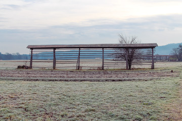 Hayrack on a meadow covered with hoarfrost.