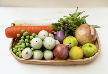 Fresh vegetables in bamboo tray on wood background
