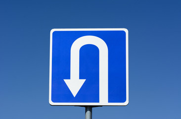 Blue road sign with U Turn traffic sign with blue sky background