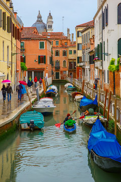 Tourists and the rowers on a rainy day in Venice