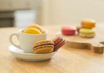 French macarons on wooden table in a kitchen