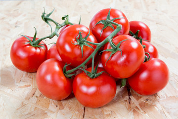 Fresh  tomatoes on a cluster over wooden  table