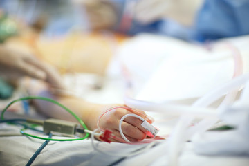 Hand of a patient with inserted plastic transfusion system