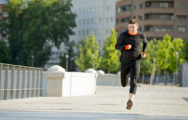 young athletic man running on urban city park in sport training