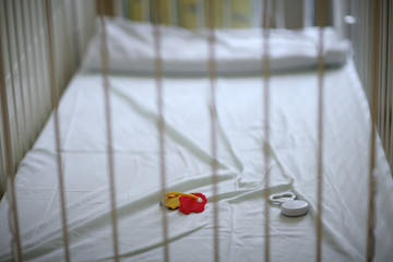 Closeup of a empty baby's crib with left toys - 84737993