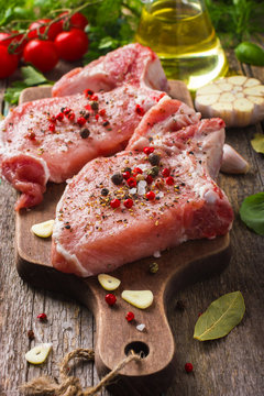 Fresh raw pork chops with spices and herbs